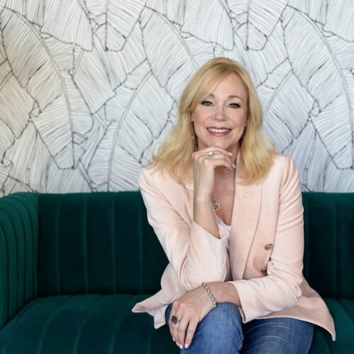 Karen Preston smiling and sitting on an office couch.